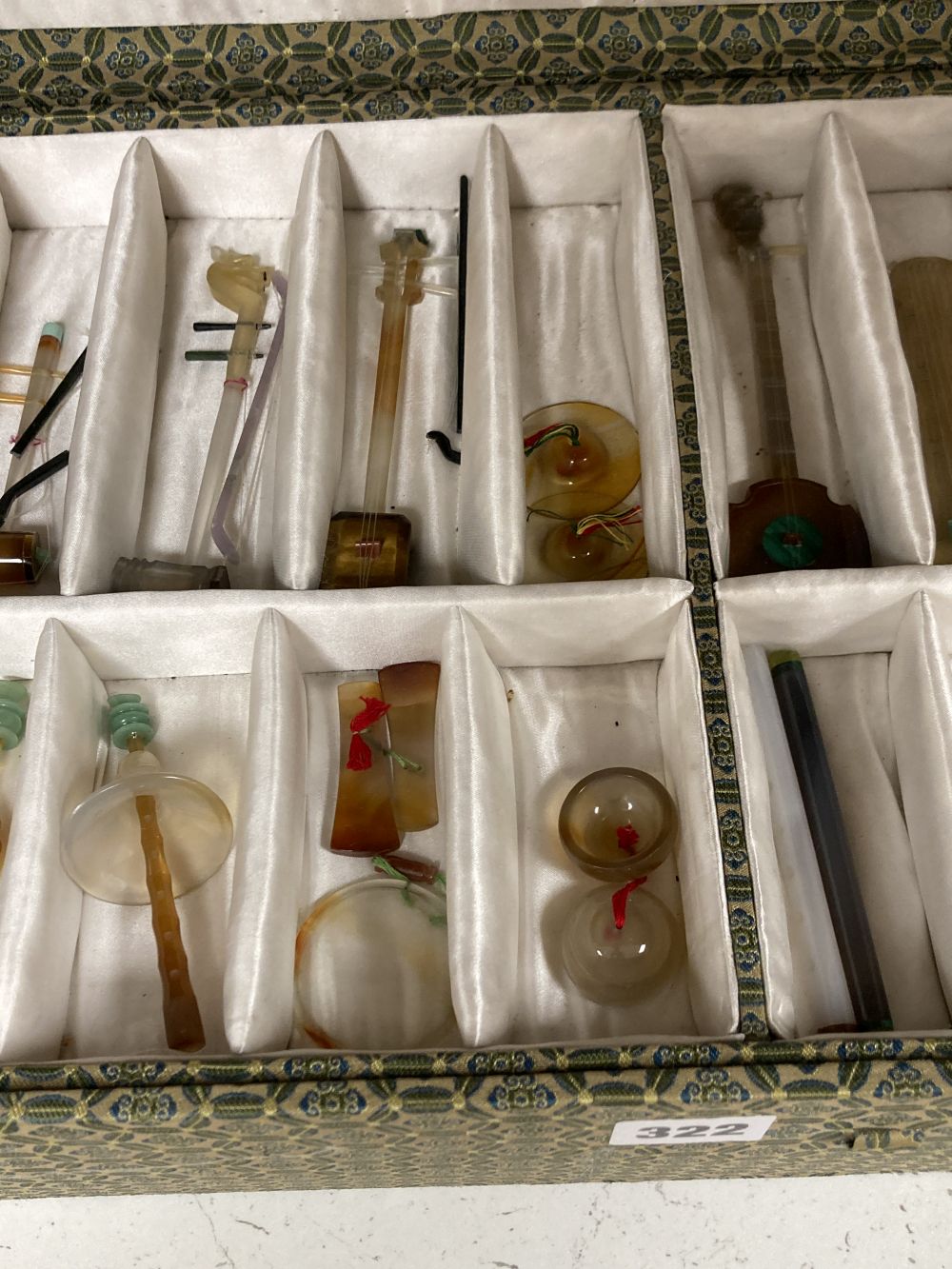 A collection of Chinese carved agate and other hardstone models of miniature musical instruments, together with hardwood stands, boxed